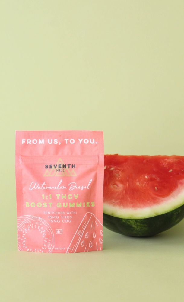 A bag of gummies sits with pieces of wood painted to look like watermelons